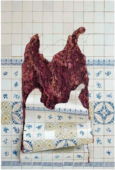 Pintura, de Adriana Varejão, com volume, sobre uma parede de azulejos, intitulada Azulejaria em carne viva. Ao centro da obra, parte dos azulejos parece estar amolecida e caída para a frente, como se a parede tivesse sido rasgada. Na abertura rasgada da parede, há carne e vísceras expostas.