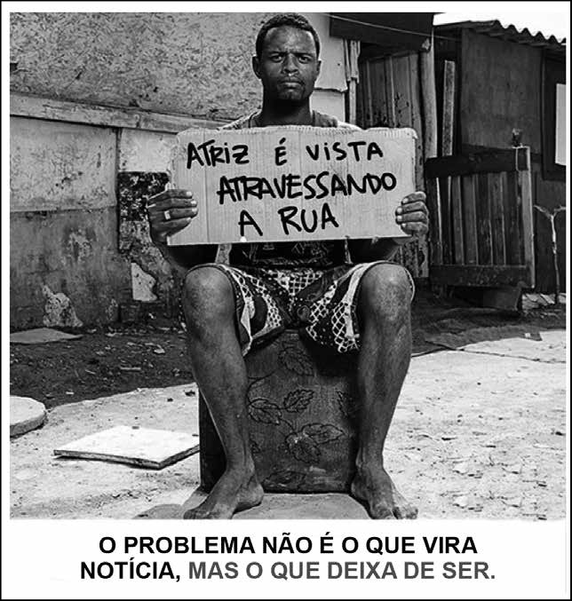 Fotografia que apresenta, em um lugar pobre, um homem negro sentado sobre um pufe velho. Descalço e de bermuda, ele segura um cartaz de papelão com a frase: “Atriz é vista atravessando a rua”. Abaixo da foto, há o texto: “O problema não é o que vira notícia, mas o que deixa de ser.”.