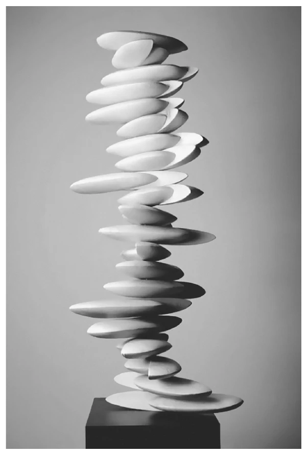 escultura de cerâmica branca formada por dezenas de discos ovais e finos empilhados de modo irregular, formando uma coluna alta e sinuosa sobre uma base escura
